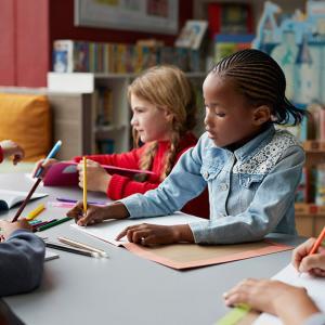 Un groupe d'enfants font du coloriage