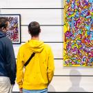 Deux personnes regardent une œuvre d'art contemporain exposée