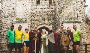Des bénévoles et des coureurs devant un château fort
