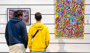 Deux personnes regardent une œuvre d'art contemporain exposée