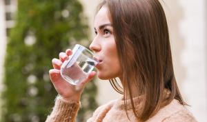 Une femme boit un verre d'eau