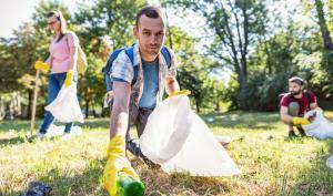 Un homme ramasse des déchets dans une forêt