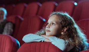 Une adolescente regarde un film au cinéma