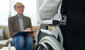 Une personne handicapée dans un fauteuil roulant devant une femme