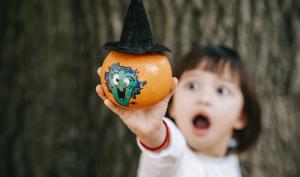 Un enfant avec une citrouille d'halloween