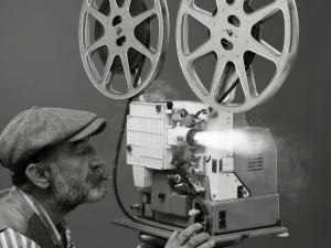 Un homme filmant avec une ancienne caméra de cinéma