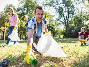 Un homme ramasse des déchets dans une forêt