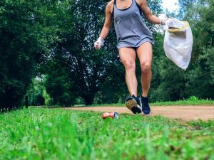 Une femme court et ramasse des déchets dans la nature