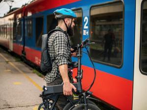 Un homme rentre dans les transports avec son vélo