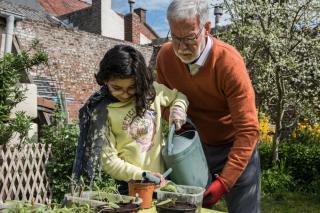 Un grand-père avec sa petite-fille dans un jardin