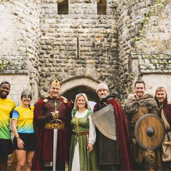 Des bénévoles et des coureurs devant un château fort