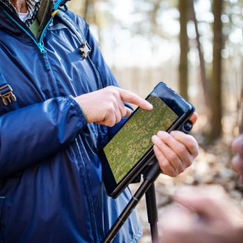 Un homme utilisant une tablette numérique dans la forêt