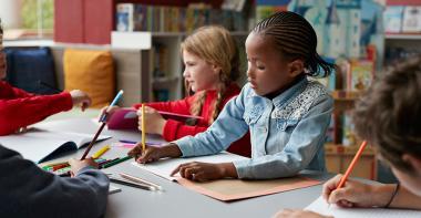 Un groupe d'enfants font du coloriage