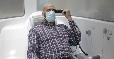Un homme prend sa température dans une cabine de téléconsultation