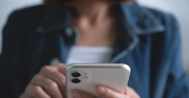 Une femme compose un numéro sur son smartphone