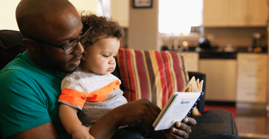Un papa lisant une histoire à un bébé