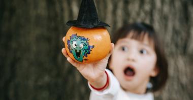 Un enfant avec une citrouille d'halloween