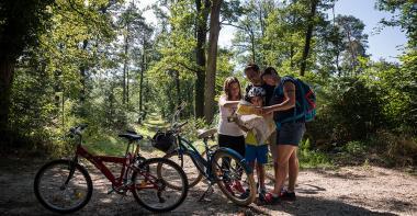 une famille avec des vélos dans une forêt