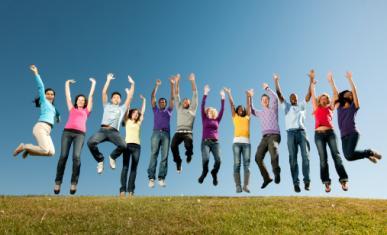 Un groupe de jeunes dans un champ sur fond de ciel bleu en train de sauter en l'air