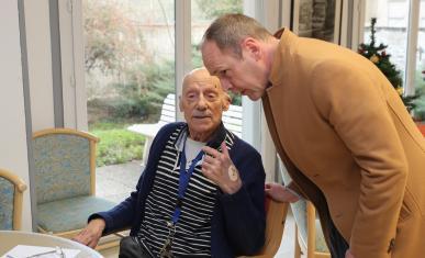 Un homme parle avec une personne âgée.