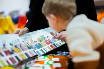 Un tout petit regarde un livre illustré