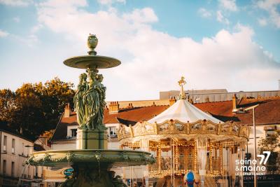 Carrousel et fontaine sur la place Saint-Jean à Melun