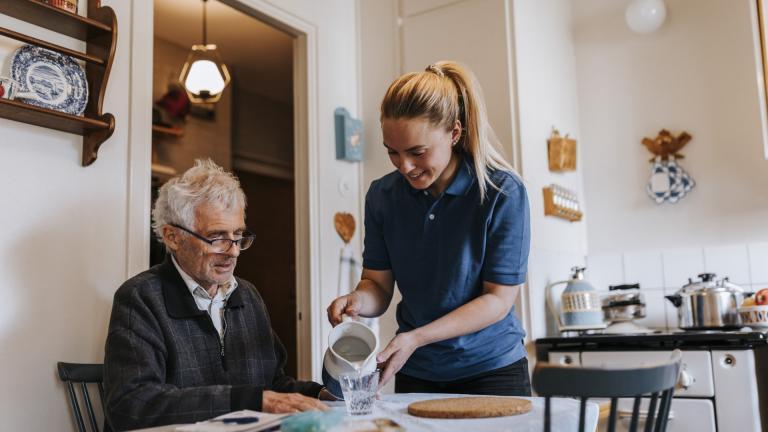 Une jeune femme aide une personne âgée