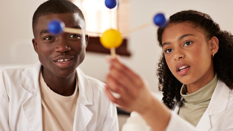 Deux adolescents étudient les atomes en cours de physique-chimie