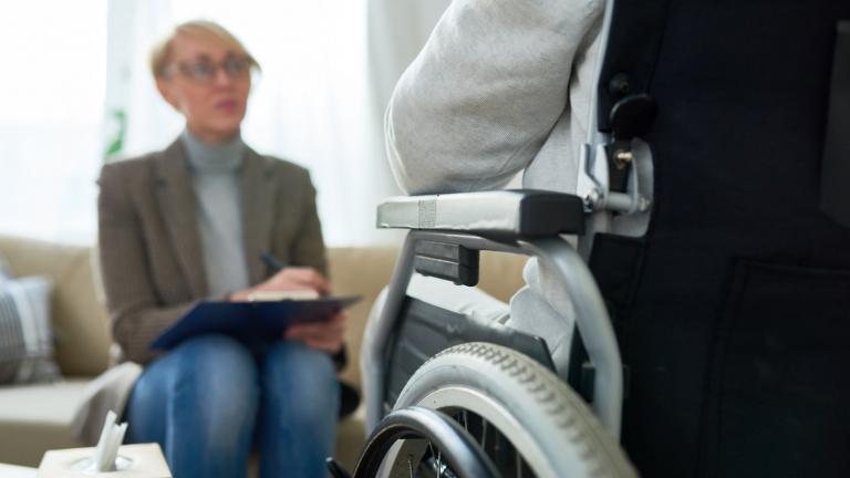 Une personne handicapée dans un fauteuil roulant devant une femme