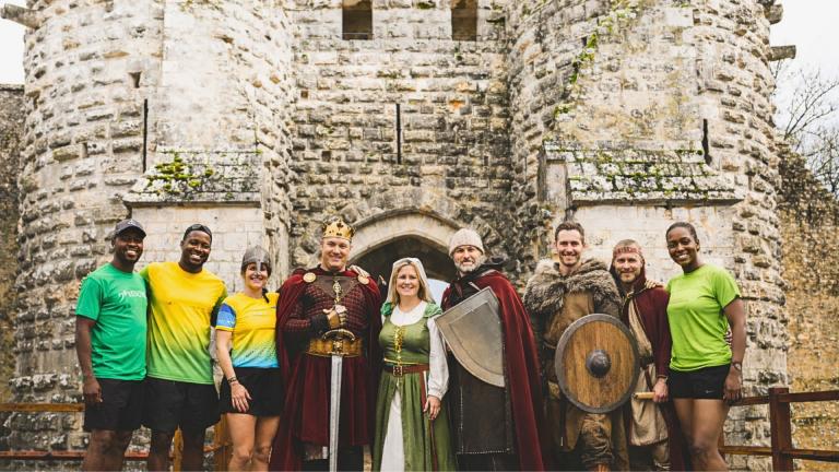 Des bénévoles et des coureurs devant un château fort