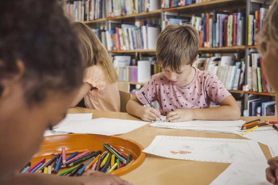 Enfant qui dessine à l'école